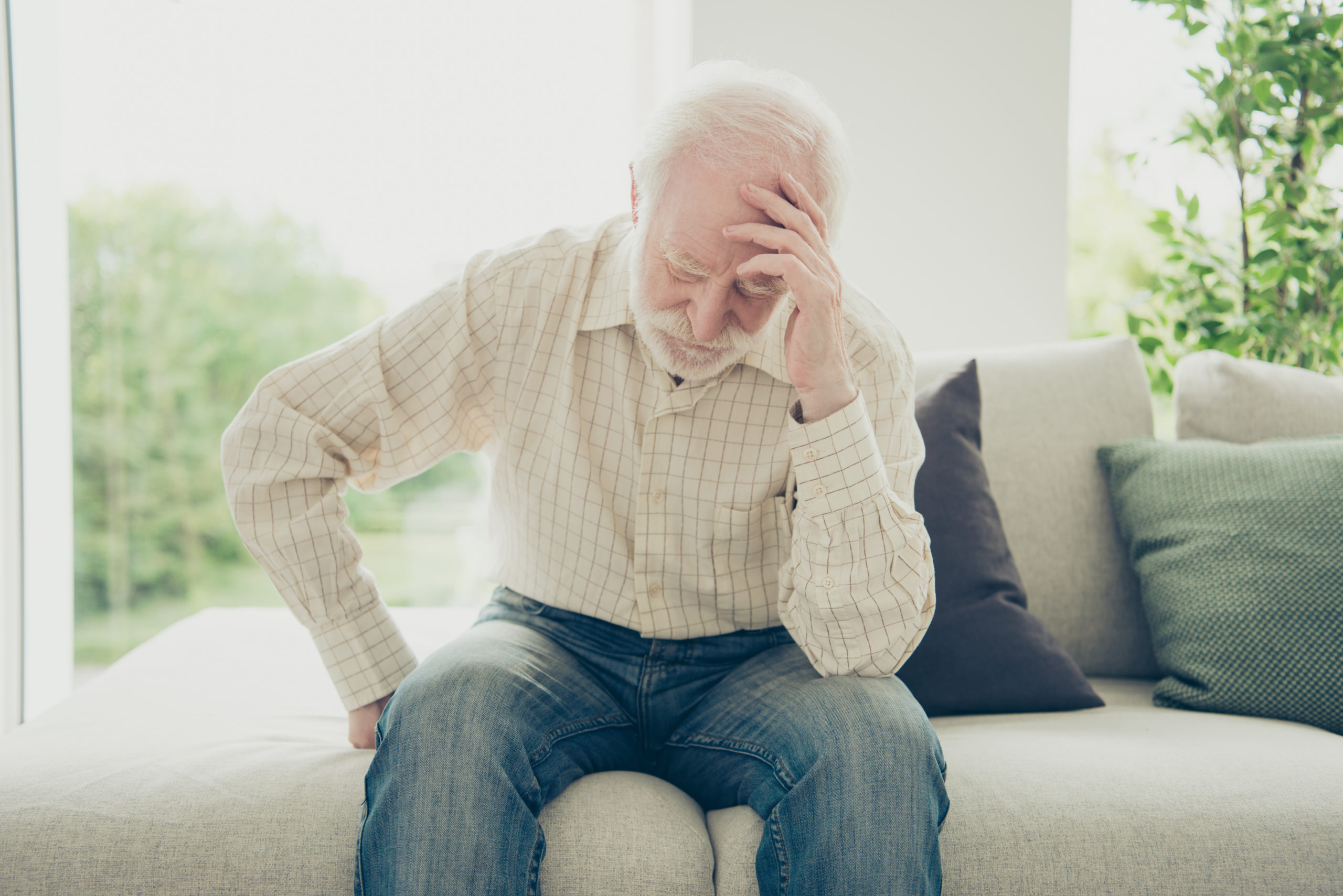 Close up portrait of grey haired grandpa with chronic pain